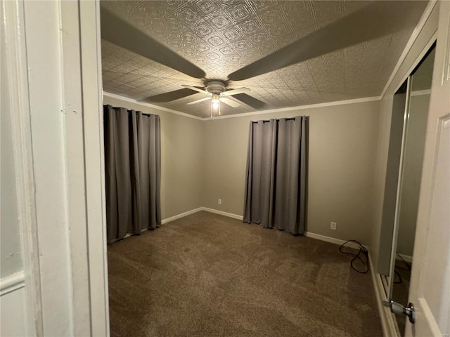 unfurnished bedroom featuring ceiling fan, a closet, crown molding, and dark colored carpet