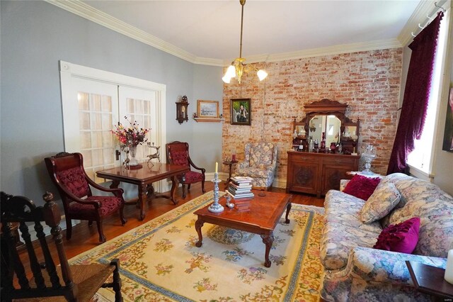 living room with crown molding, hardwood / wood-style flooring, and an inviting chandelier