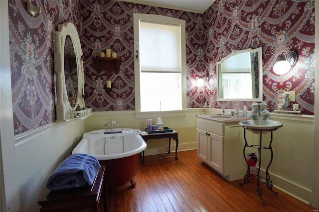 bathroom with vanity, a wealth of natural light, hardwood / wood-style floors, and a washtub