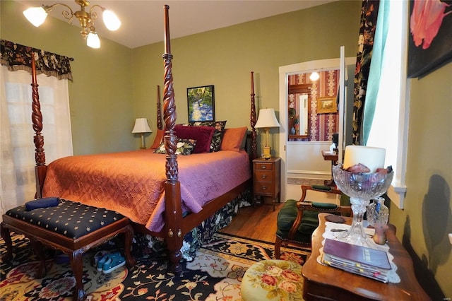 bedroom with hardwood / wood-style floors and an inviting chandelier