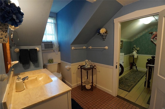 bathroom featuring cooling unit, vanity, toilet, and vaulted ceiling