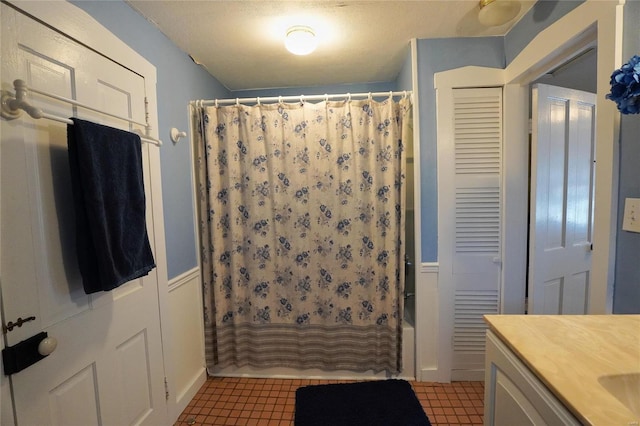 bathroom with tile patterned flooring, vanity, a textured ceiling, and shower / bath combo with shower curtain