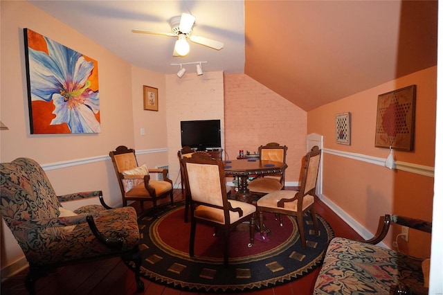 living area featuring hardwood / wood-style flooring, vaulted ceiling, track lighting, and ceiling fan