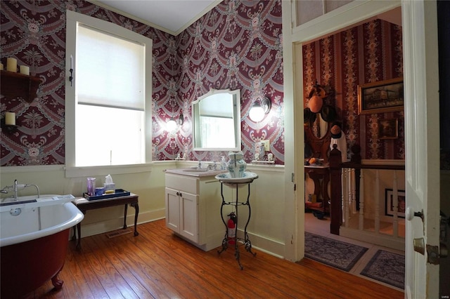 bathroom with wood-type flooring, a bath, and vanity