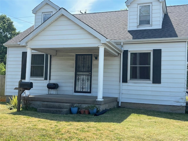 cape cod home with a porch and a front yard