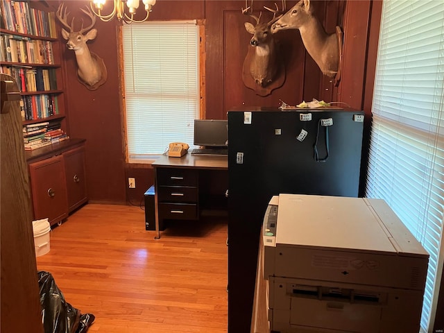 office featuring light hardwood / wood-style floors and a notable chandelier