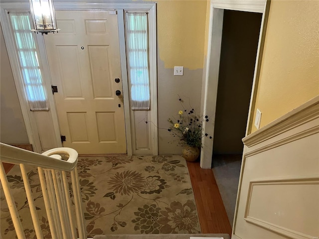 foyer entrance featuring hardwood / wood-style floors and a notable chandelier