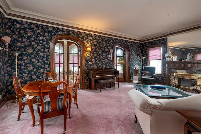 carpeted dining area with french doors, a fireplace, and crown molding