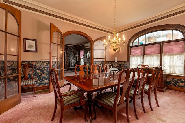 dining room with carpet, crown molding, and a chandelier