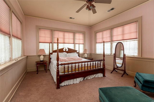 carpeted bedroom featuring ceiling fan and multiple windows