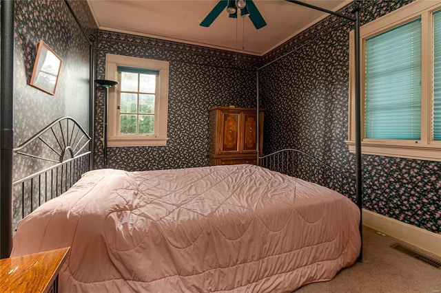 bedroom with carpet, ceiling fan, and crown molding