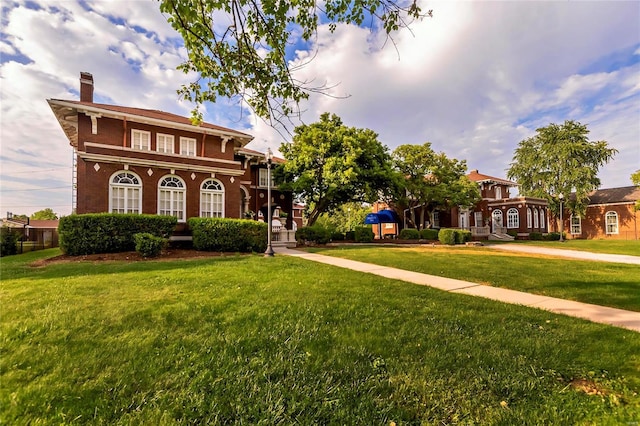 view of front of house featuring a chimney and a front yard