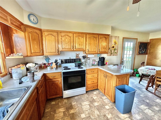 kitchen featuring kitchen peninsula, electric range, backsplash, and sink