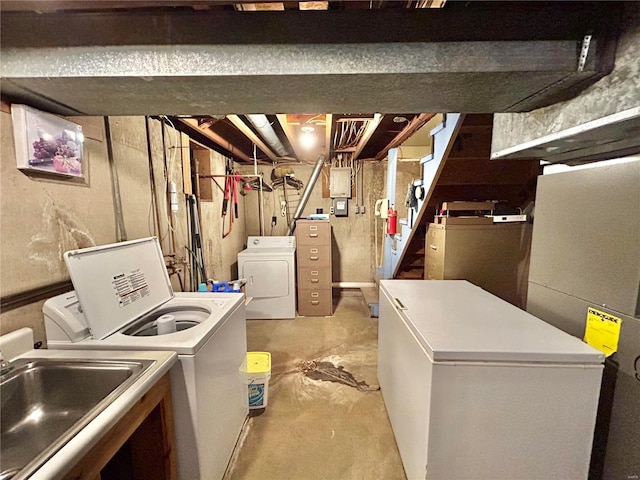 basement with washer and clothes dryer, refrigerator, and sink