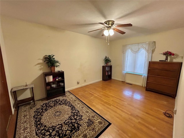 sitting room with wood-type flooring and ceiling fan