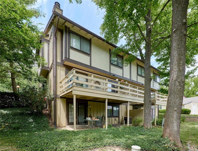 rear view of property featuring a patio area and a wooden deck