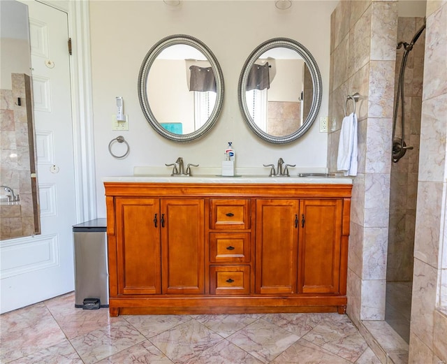 bathroom with tiled shower, tile patterned flooring, and double sink vanity