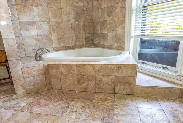 bathroom with a relaxing tiled tub and tile patterned floors