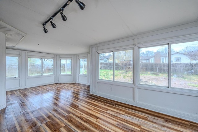 unfurnished sunroom featuring rail lighting