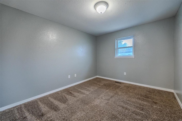 unfurnished room featuring carpet flooring and a textured ceiling