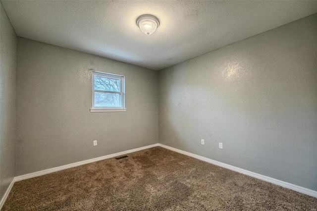 carpeted empty room with a textured ceiling