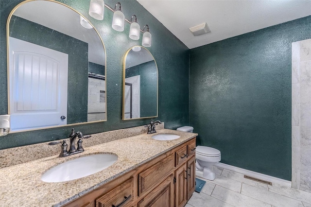 bathroom featuring tile patterned flooring, vanity, and toilet