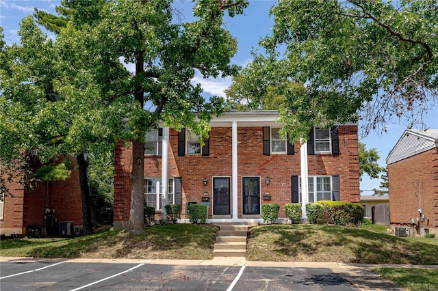 view of front of property with central AC and a front lawn