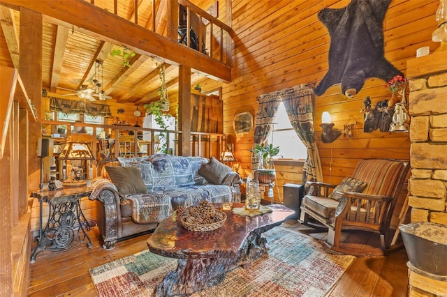 living room featuring wood-type flooring, a healthy amount of sunlight, wooden ceiling, and wooden walls