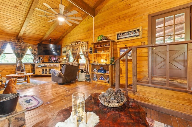 living room with vaulted ceiling with beams, wood ceiling, hardwood / wood-style flooring, and wooden walls