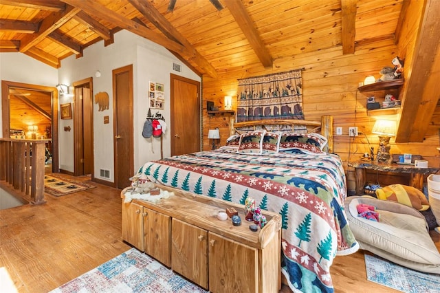 bedroom featuring wooden walls, visible vents, lofted ceiling with beams, wood ceiling, and wood finished floors