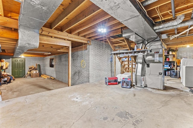 unfinished below grade area featuring washer / dryer and brick wall