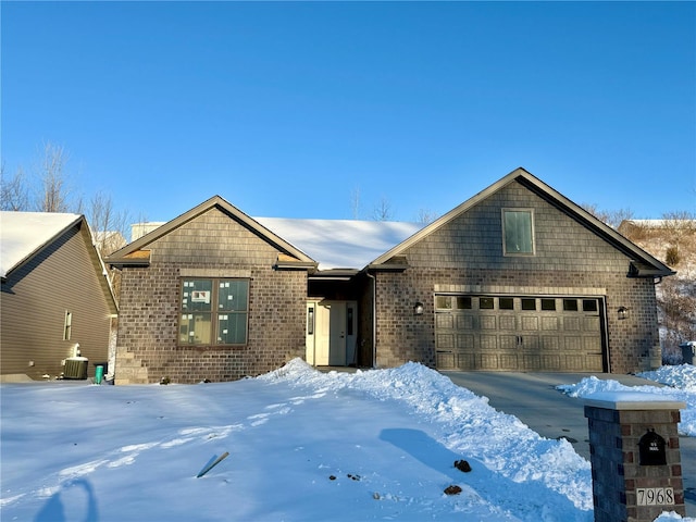 view of front of home featuring central air condition unit and a garage