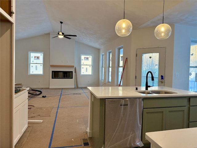 kitchen with dishwasher, sink, hanging light fixtures, green cabinetry, and an island with sink