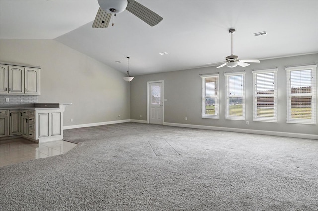 unfurnished living room featuring ceiling fan, lofted ceiling, and light carpet