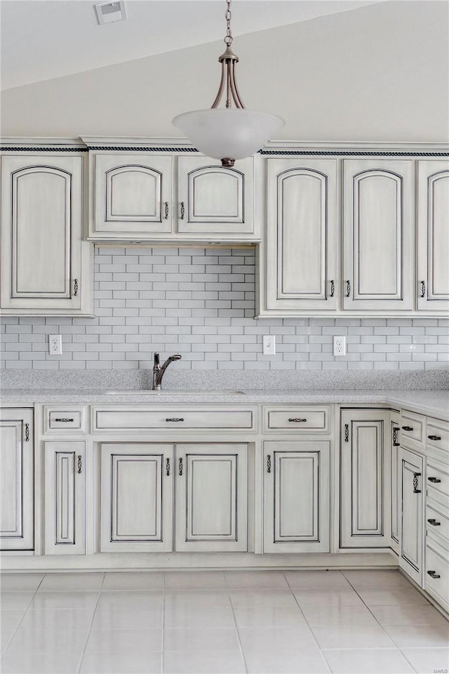 kitchen featuring decorative light fixtures, light tile patterned flooring, sink, and vaulted ceiling