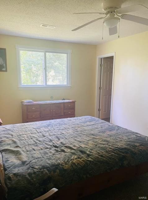 bedroom with a textured ceiling and ceiling fan