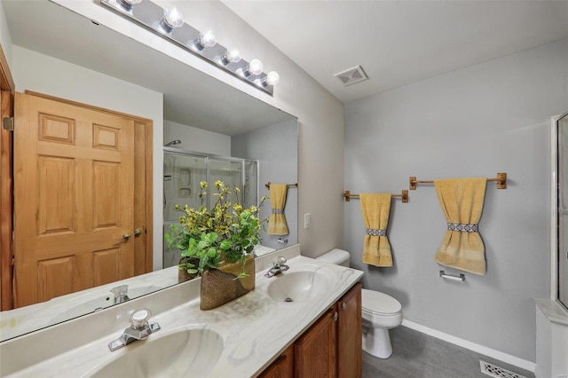 bathroom featuring vanity, a shower with shower door, and toilet