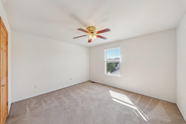 spare room featuring ceiling fan and light carpet