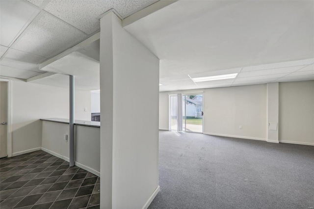 basement with dark carpet and a drop ceiling