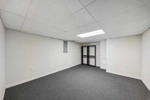 basement with dark carpet, a drop ceiling, and electric panel