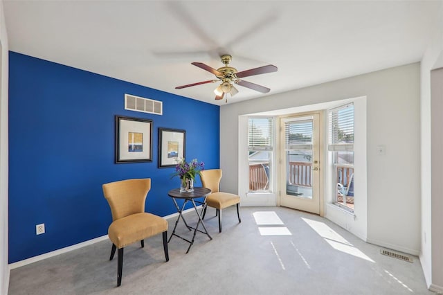 living area featuring ceiling fan and light colored carpet