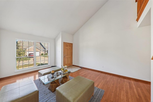 sitting room with high vaulted ceiling and light wood-type flooring