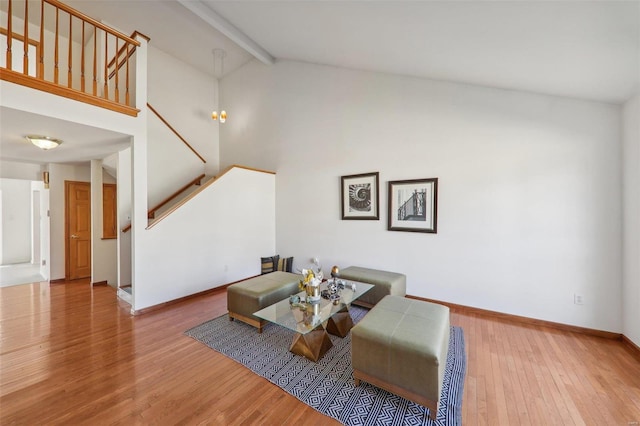 living area featuring beam ceiling, high vaulted ceiling, and hardwood / wood-style flooring