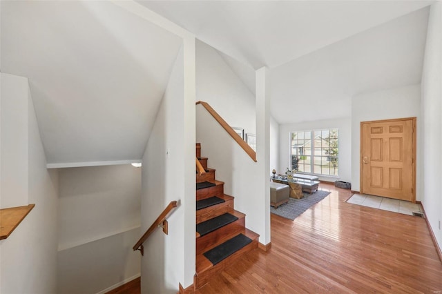 foyer entrance with lofted ceiling and light hardwood / wood-style floors