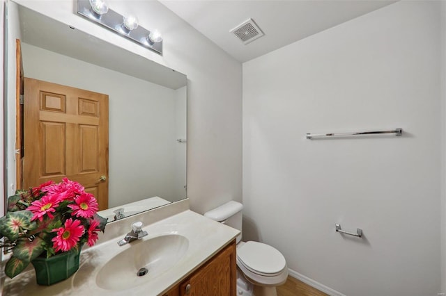 bathroom featuring hardwood / wood-style floors, vanity, and toilet