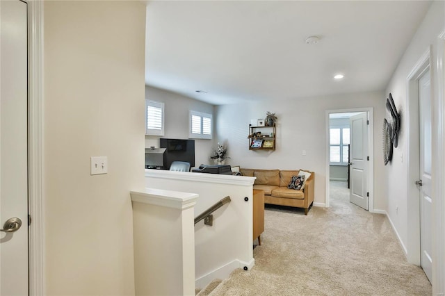 hall with light colored carpet