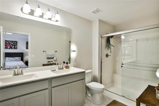 bathroom with tile patterned floors, double vanity, an enclosed shower, and toilet