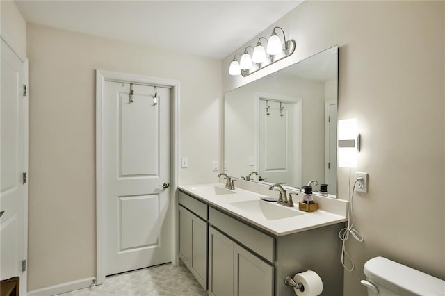 bathroom with tile patterned flooring, dual bowl vanity, and toilet