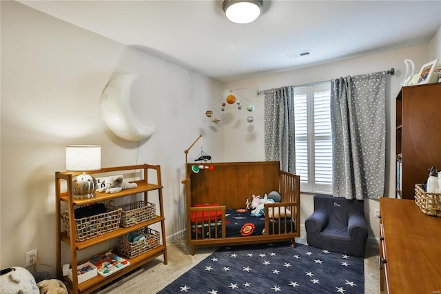 bedroom featuring carpet floors and a nursery area