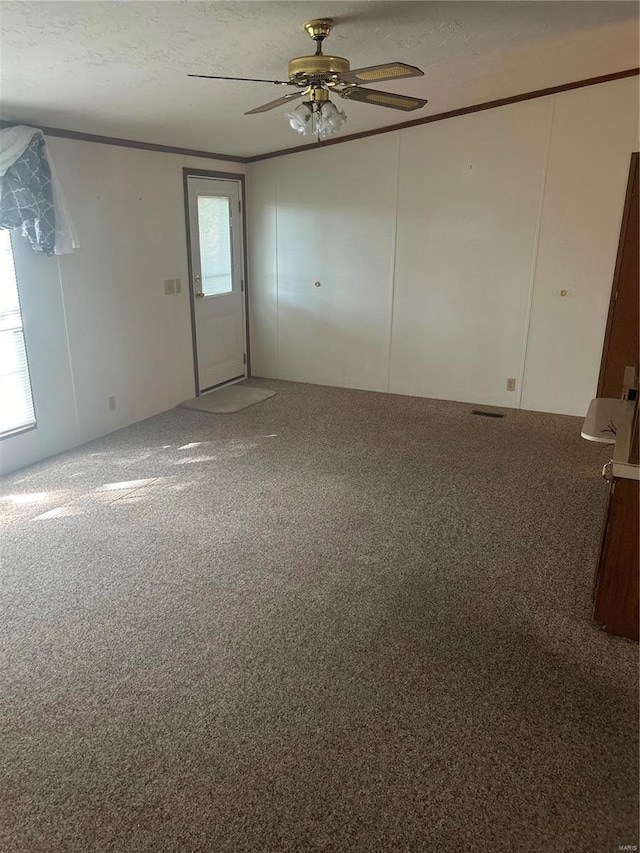 empty room with ceiling fan, carpet flooring, and a textured ceiling